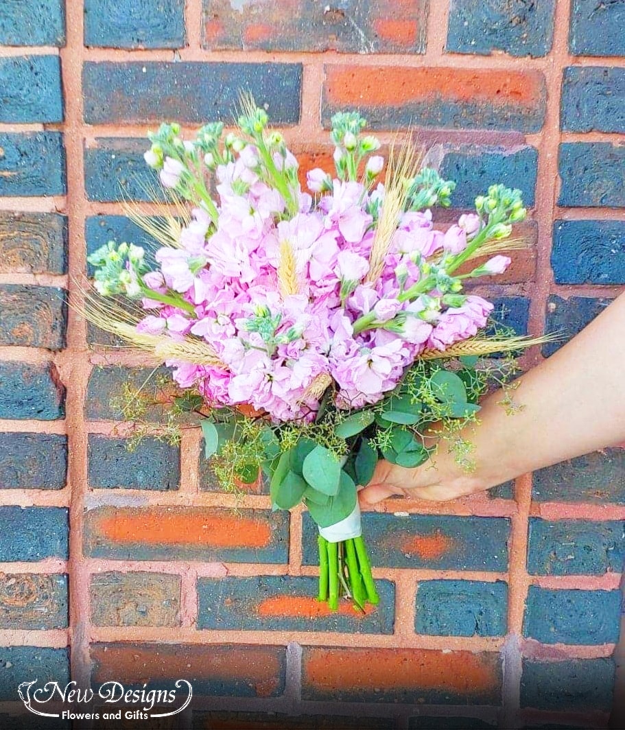 A stunning bouquet of blush stock with wheat stems spiking through